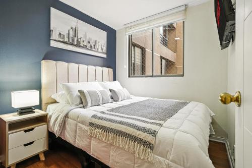 a bedroom with a large bed with a window at Estreno - Bellas Artes Turístico in Santiago