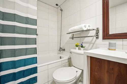 a bathroom with a toilet and a tub and a sink at Estreno - Bellas Artes Turístico in Santiago