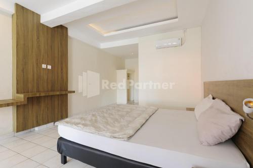 a bedroom with a bed in a room at Pulau Bali Hotel Denpasar RedPartner in Denpasar