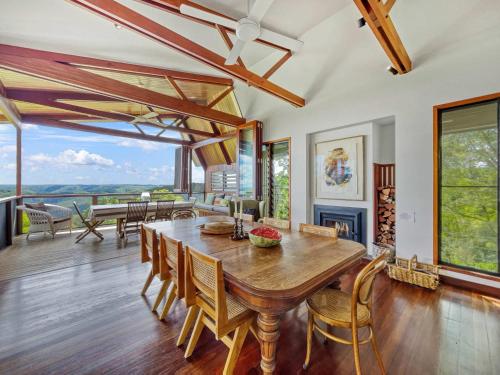 a dining room with a wooden table and chairs at Luxurious Mountain Retreat near Maleny in Booroobin