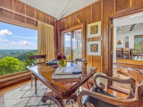 a dining room with a table and a large window at Luxurious Mountain Retreat near Maleny in Booroobin