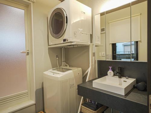 a small bathroom with a sink and a washing machine at Kotonoyado Chizu - Vacation STAY 23155v in Kotohira