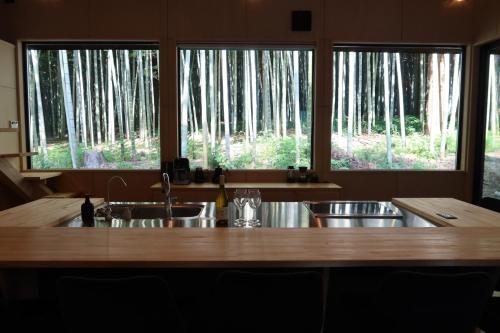 a kitchen with a large wooden table and two windows at and FOREST Katsuura Take no Hanare - Vacation STAY 91561v in Katsuura