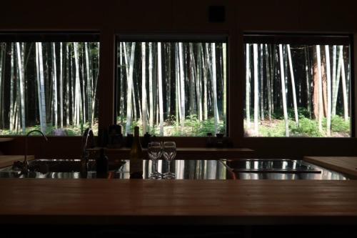 a kitchen with trees seen through two windows at and FOREST Katsuura Take no Hanare - Vacation STAY 91561v in Katsuura