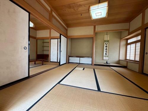 an empty room with a rug in a room with windows at みんぱく明治村 in Tome