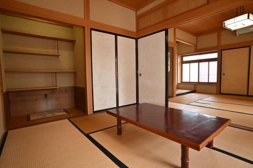a room with a wooden table and shelves at みんぱく明治村 in Tome