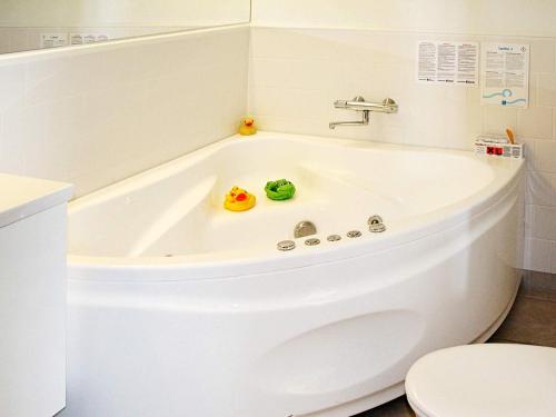 a white bath tub in a bathroom with a toilet at 6 person holiday home in Bagenkop in Bagenkop