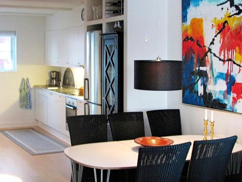 a dining room table with chairs and a painting on the wall at 6 person holiday home in Bagenkop in Bagenkop