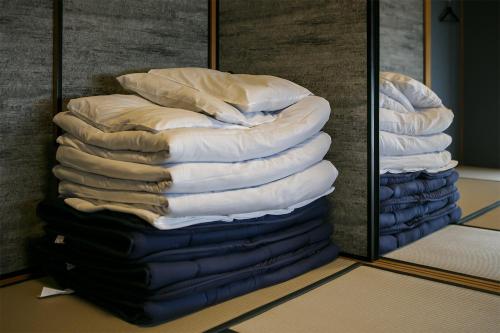 einem Stapel Kissen vor einem Spiegel in der Unterkunft Gracia Kamiiida - Vacation STAY 18274 in Nagoya
