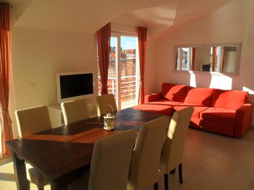 a living room with a table and a red couch at Apartments Leut in Jezera