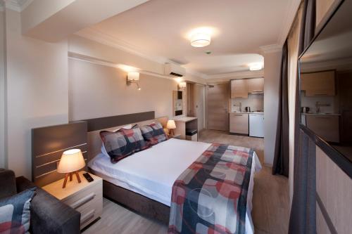 a small bedroom with a bed and a couch at Atrium Apart Otel in Altınyunus