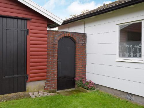 a red and white house with a black door at 5 person holiday home in GLOMMEN-By Traum in Glommen