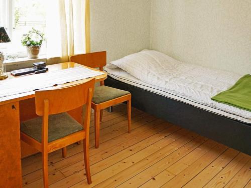 a small room with a bed and a desk and chair at 6 person holiday home in GAMLEBY-By Traum in Gamleby
