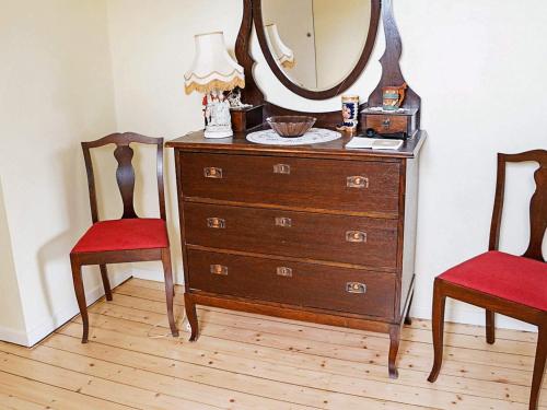 a dresser with a mirror and two chairs in a room at 6 person holiday home in GAMLEBY-By Traum in Gamleby