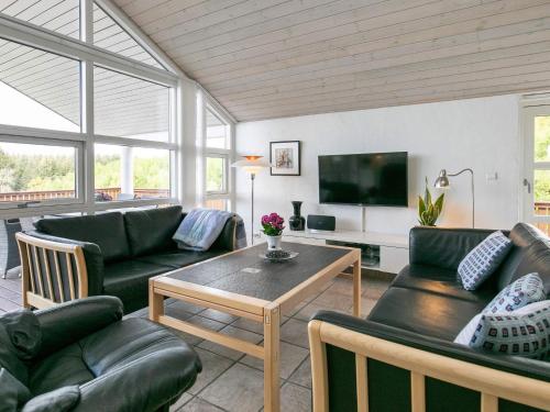 a living room with couches and a table and a tv at 4 star holiday home in Skals in Skals