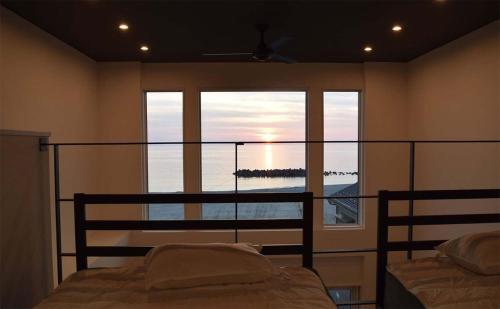 a bedroom with a bed and a large window at Tabinoteitaku Y-beach - Vacation STAY 51860v in Tsuruoka