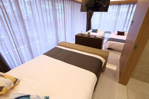 a hotel room with two beds and a television at Tabi no Teitaku Okinawa Naha - Vacation STAY 91264v in Naha