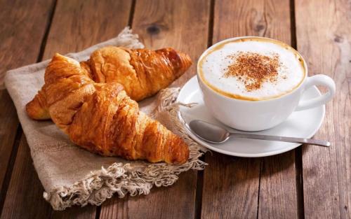 a cup of coffee and some croissants on a table at Madam Seven Tam Coc in Vũ Lâm