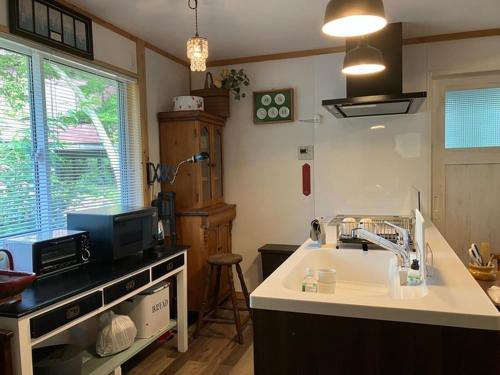 une cuisine avec un évier et un micro-ondes dans l'établissement Cottage Dejavu & Harvest - Vacation STAY 03241v, à Uwano
