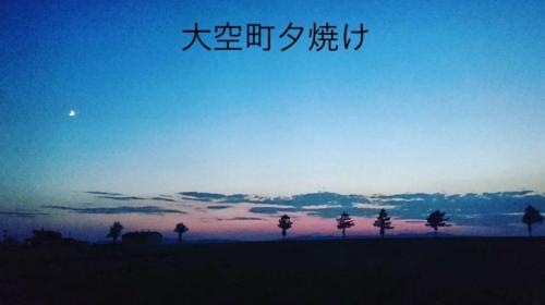 a picture of a sunset with writing in the sky at NU1 Guesthouse NUI okhotsk女満別 in Abashiri