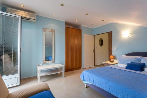 a blue bedroom with a bed and a window at Adriana Apartments in Herceg-Novi