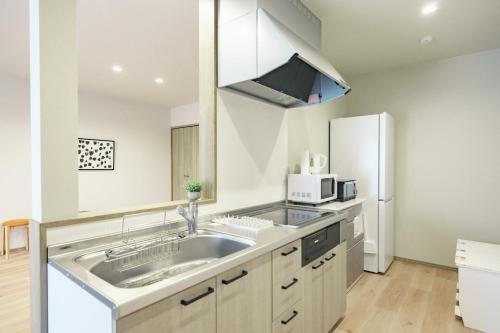 a kitchen with a sink and a refrigerator at Green Peak - Vacation STAY 05851v in Minami Aso