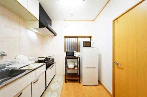 a small kitchen with a refrigerator and a sink at minpaku Blanco Honjin - Vacation STAY 18357 in Nagoya