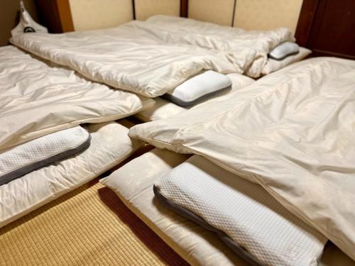 3 unmadene Betten auf dem Boden in einem Zimmer in der Unterkunft Hakusanjinjya Santokukan - Vacation STAY 18679 in Takasaki