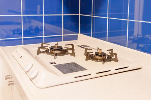 a white stove top with two burners on it at Pangoo Shinagawa Room 205 - Vacation STAY 18364 in Tokyo