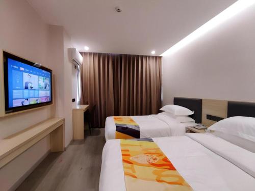 a hotel room with two beds and a flat screen tv at Shell Hotel Wuxi Huishan District Chang'an Town in Wuxi