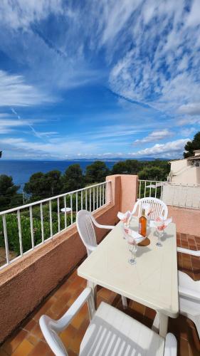 a white table with wine glasses on a balcony at Panoramic Levant view–4 ppl–Sea–Pool–Tennis in Saint-Raphaël