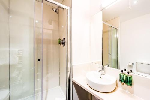 a bathroom with a sink and a shower at The Lodge At Perth Racecourse in Perth