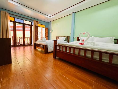 a bedroom with two beds and a wooden floor at Bangalow Coconut corner in Ban Laem Sai