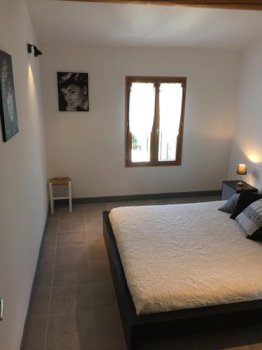 une chambre avec un grand lit et une fenêtre dans l'établissement Maison de vacances Jocelyne, à Lauris