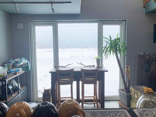 a room with a table and chairs and a large window at Svalbard Residence - Vacation STAY 18446 in Minamifurano