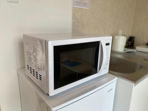 a microwave oven sitting on top of a kitchen counter at THE LAND HOTEL - Vacation STAY 16151v in Arao
