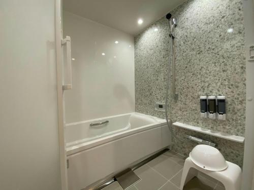 a white bathroom with a tub and a toilet at THE LAND HOTEL - Vacation STAY 15680v in Arao