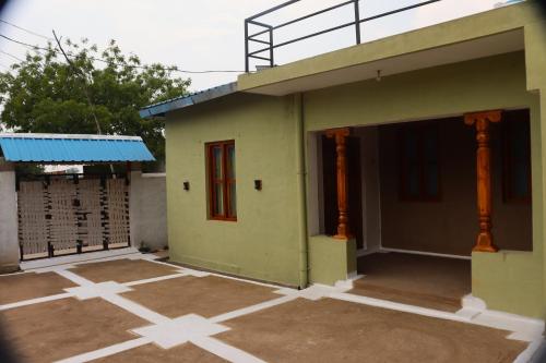 a green house with a red door on the side at Vindhyavan Mud House in Panna