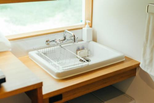 a white sink with a basket on a wooden table at MANANI - Vacation STAY 16612v in Nago