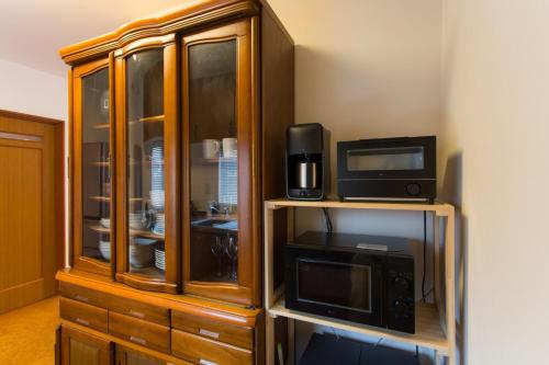 a wooden cabinet with two microwaves and a microwave at ObihiroINN - Vacation STAY 18480 in Obihiro