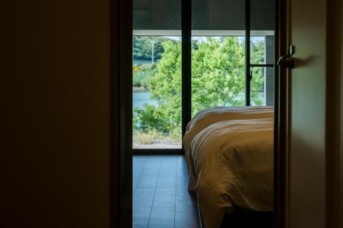 a bedroom with a bed and a view of a window at Seaside Villa N - Vacation STAY 21991v in Mitsugoe