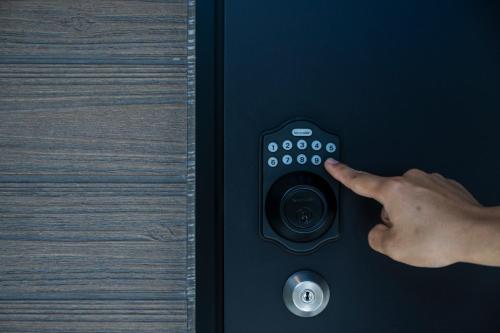 a hand pressing a remote control on a door at Seaside Villa N - Vacation STAY 21988v in Mitsugoe