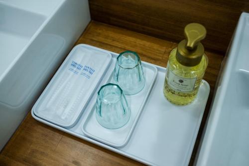 a bottle of honey and two glasses in a drawer at Seaside Villa N - Vacation STAY 21989v in Mitsugoe