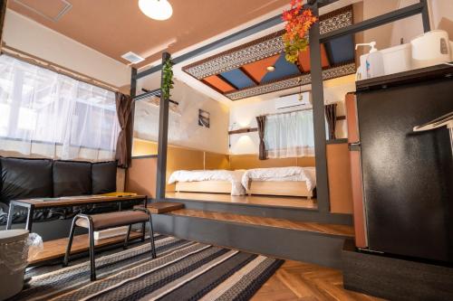 ein Zimmer mit zwei Betten und einem Tisch und Stühlen in der Unterkunft Hyuga Surf Camp 105 - Vacation STAY 29665v in Hyuga