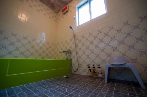 ein Badezimmer mit grüner Badewanne und WC in der Unterkunft Hyuga Surf Camp 105 - Vacation STAY 29665v in Hyuga