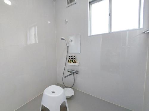 a white bathroom with a toilet and a window at Hyuga Surf Camp 101 - Vacation STAY 29178v in Hyuga