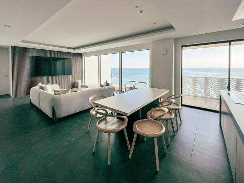 a living room with a couch and a table and chairs at CORAL RESORT VILLA atsuhama - Vacation STAY 21316v in Sumoto