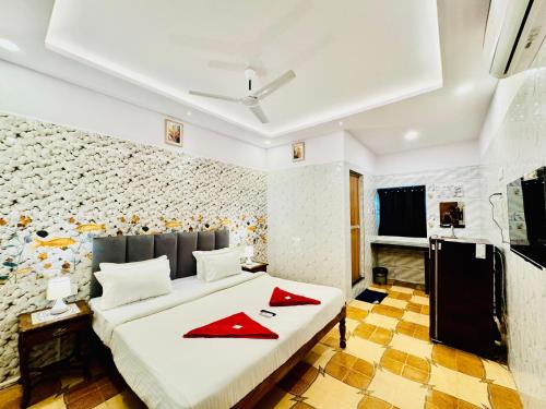a bedroom with a bed with red napkins on it at Bluebell House in Calangute