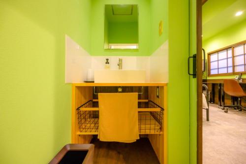 a kitchen with a sink and a green wall at Hyuga Surf Camp102 - Vacation STAY 31830v in Hyuga