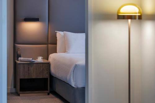a bedroom with a bed and a table with a lamp at Oakwood Premier Melbourne in Melbourne